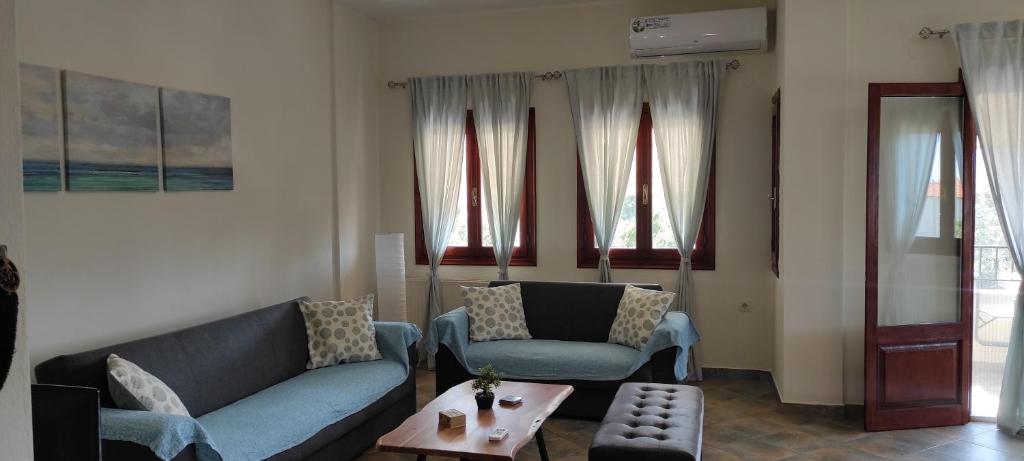 uma sala de estar com dois sofás e uma mesa em Orange Garden em Kala Nera