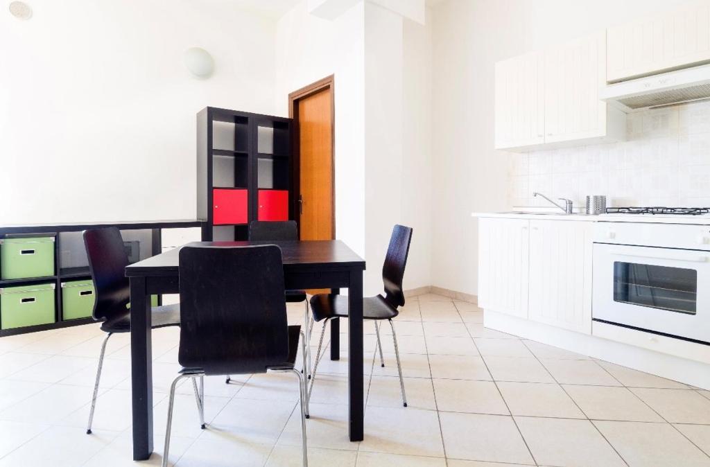 une cuisine avec une table noire et des chaises noires dans l'établissement Cozy 55-m2 flat close to the countryside in Narni, à Narni