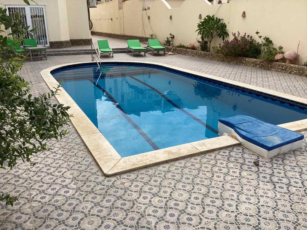 ein Swimmingpool mit einem Stuhl und einem blauen Pool in der Unterkunft Jasmine villa in Hurghada