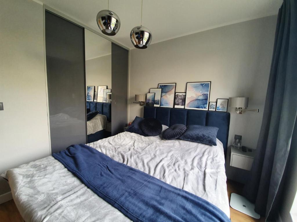 sypialnia z łóżkiem i dużym lustrem w obiekcie Nadmorski apartament premium w mieście Gdynia