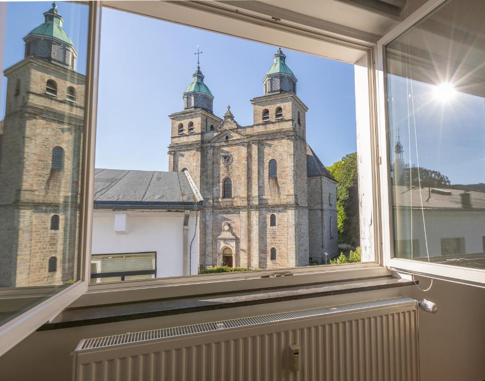 une fenêtre ouverte avec vue sur une église dans l'établissement Appartement de standing avec parking privé, à Malmedy