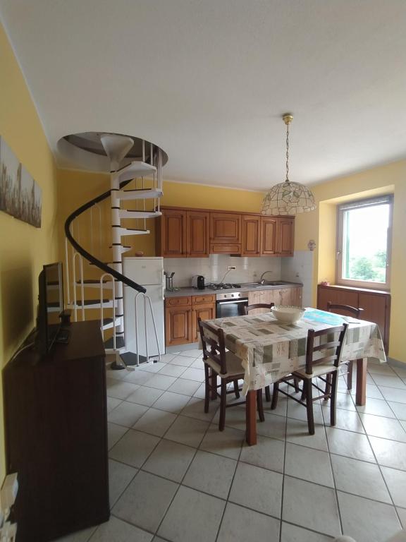 a kitchen with a table and chairs and a staircase at Bilocale La Tezia in Marciana Marina