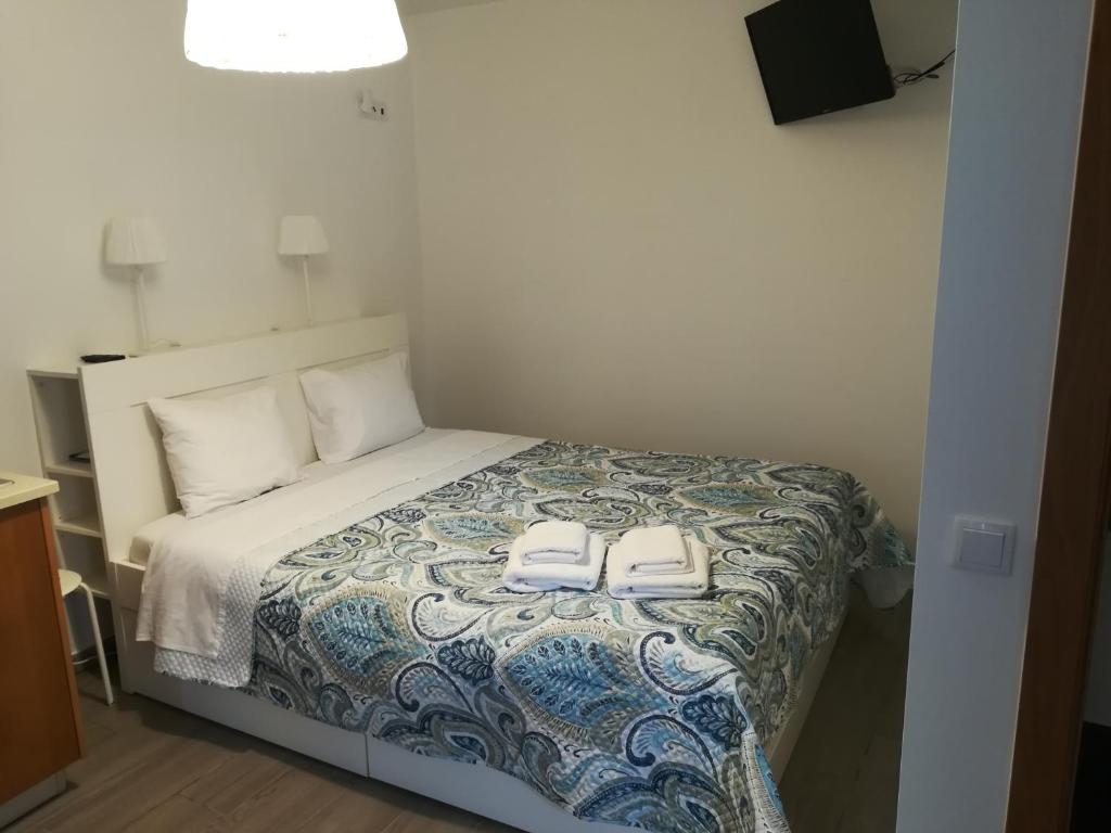 a bedroom with a bed with two white shoes on it at Isaura Home in Peniche