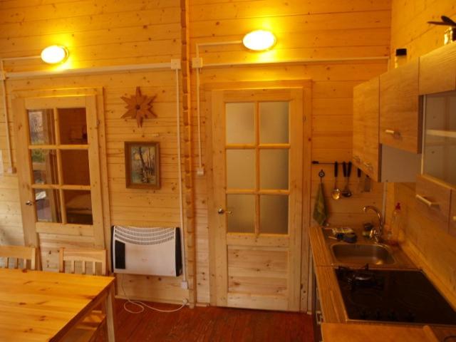 ラダバにあるRadawa Leśne Domki - Leśny domekの木製の壁のキッチン、シンク、カウンターが備わります。