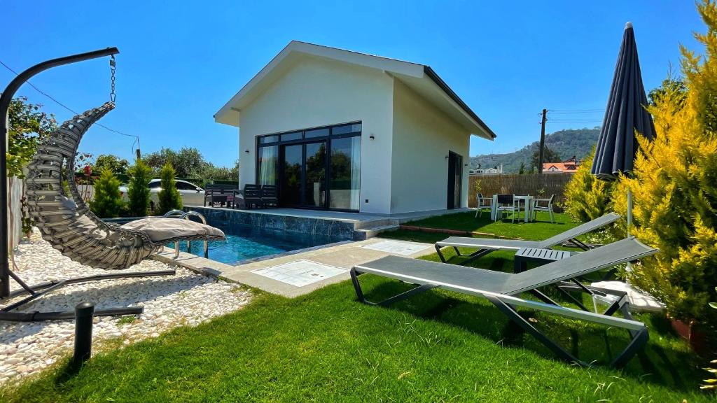 uma casa com piscina e uma rede num quintal em Honeymoon Villa in Gocek em Göcek