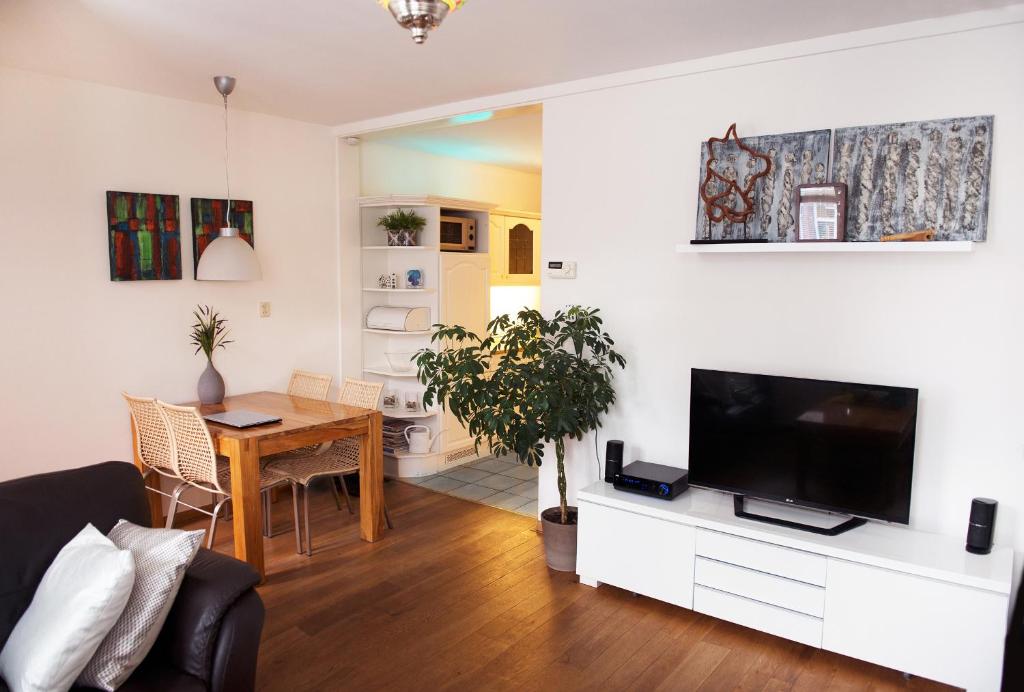 a living room with a couch and a table with a tv at Vakantiehuis Katwijk in Katwijk