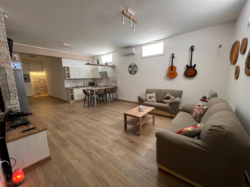 ein Wohnzimmer mit Sofa und Gitarren an der Wand in der Unterkunft Tavernetta Open space in Specchia