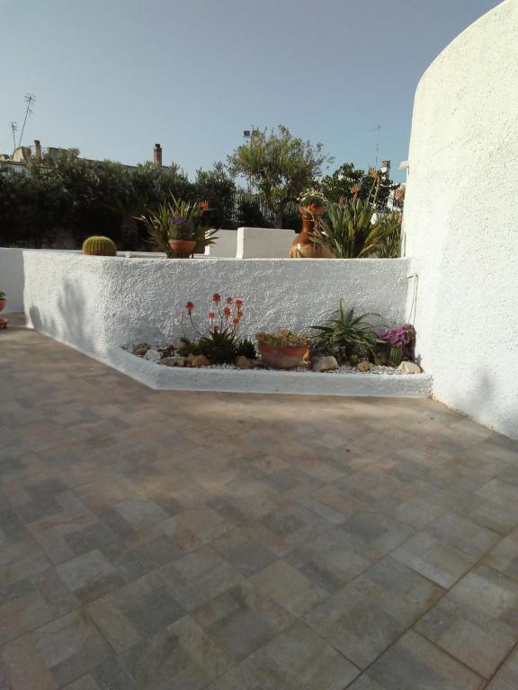 a retaining wall with potted plants on a patio at Villa Anna Maria in Polignano a Mare