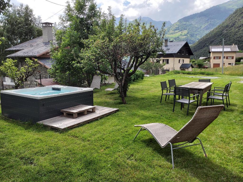 a backyard with a pool and a table and chairs at Tres bel appartement dans une maison avec SPA in Séez