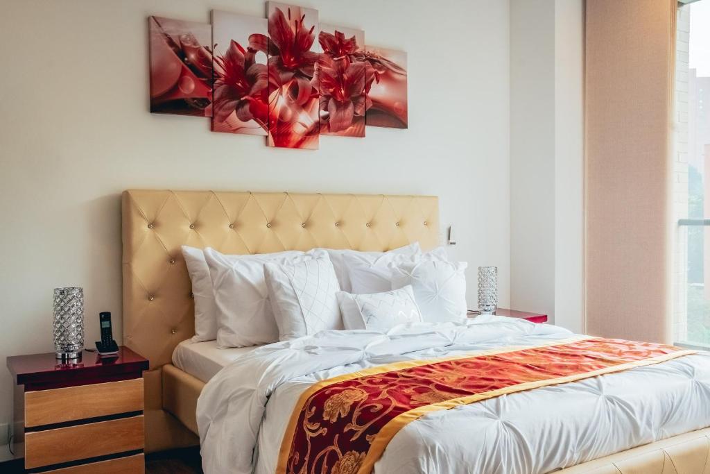 1 dormitorio con 1 cama grande y una pintura en la pared en Poblado, Great Location, Luxury building, en Medellín