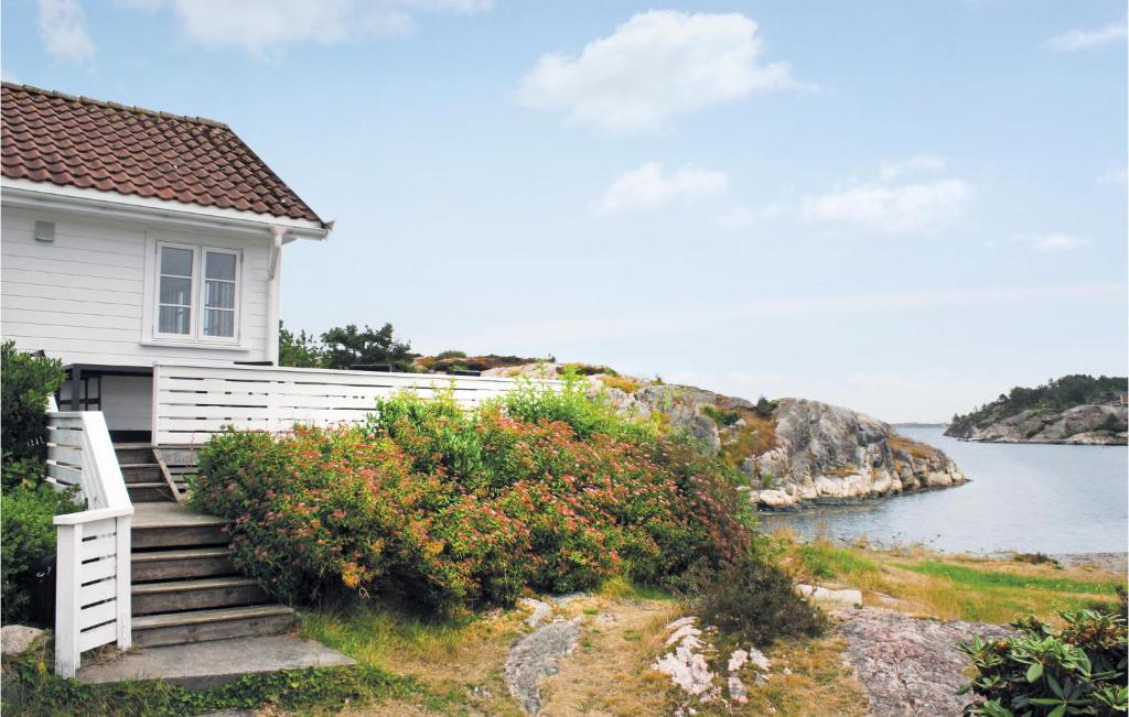 una casa bianca con scale accanto a un corpo d'acqua di Holiday Home Flekkerøy Paulen Iii a Møvik
