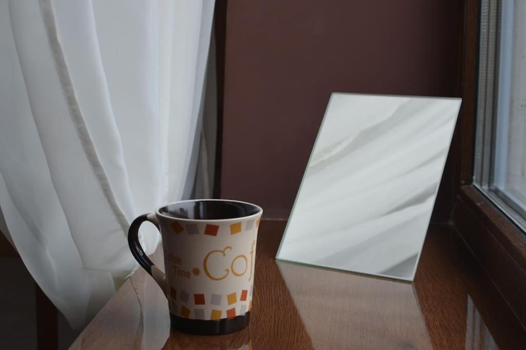 a coffee cup sitting on a table next to a window at Rooms in the center of Lviv in Lviv