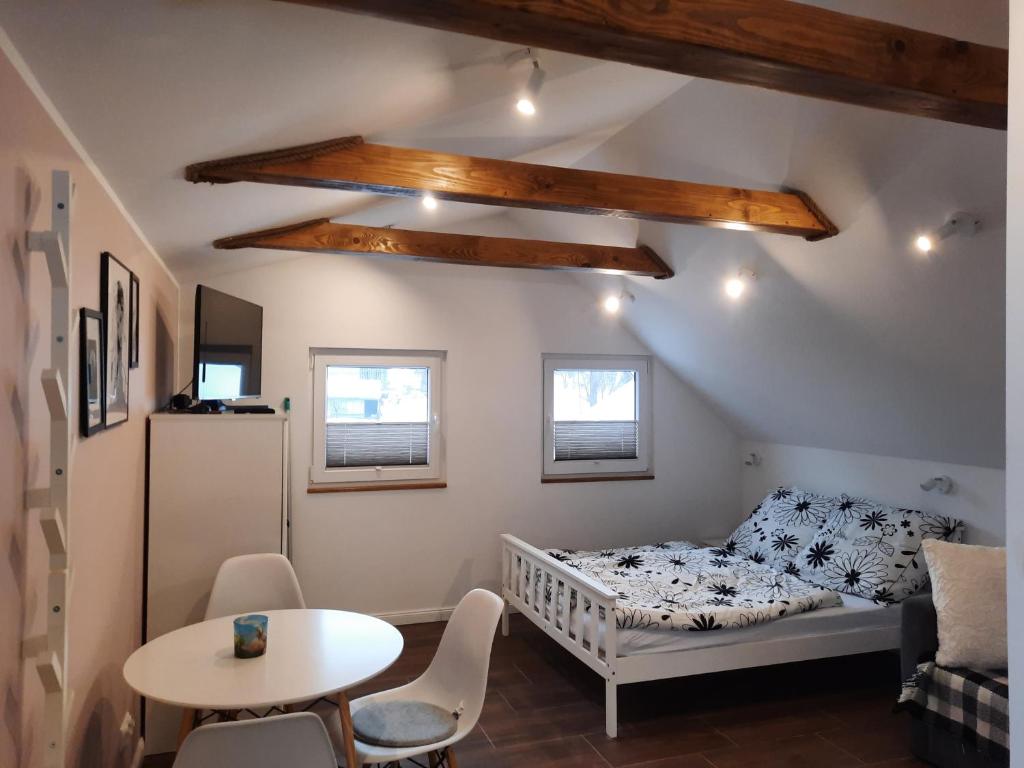 Dormitorio pequeño con cama y mesa en Apartament na górce, en Uherce Mineralne
