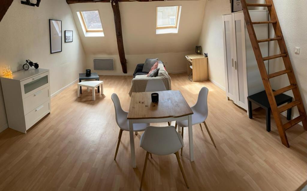 una sala de estar con mesa y sillas y un loft en L'autunette au quartier historique d'Autun, en Autun