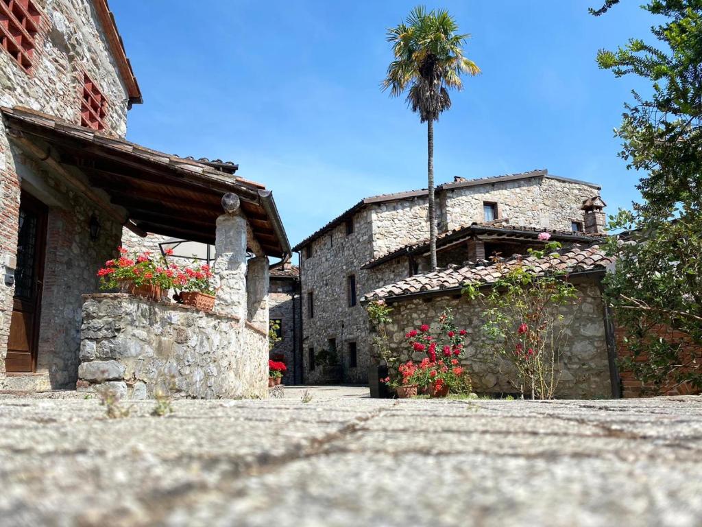 un edificio de piedra con una palmera en el fondo en Borgo Giusto Tuscany, en Diecimo