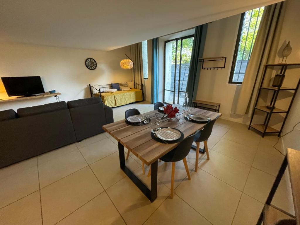 a living room with a table and a couch at Gîte Douceur de Provence in Maubec