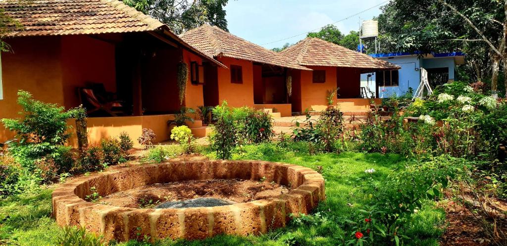 a garden in front of a house at Kudil Mud Cottages, Cheemeni in Peringom
