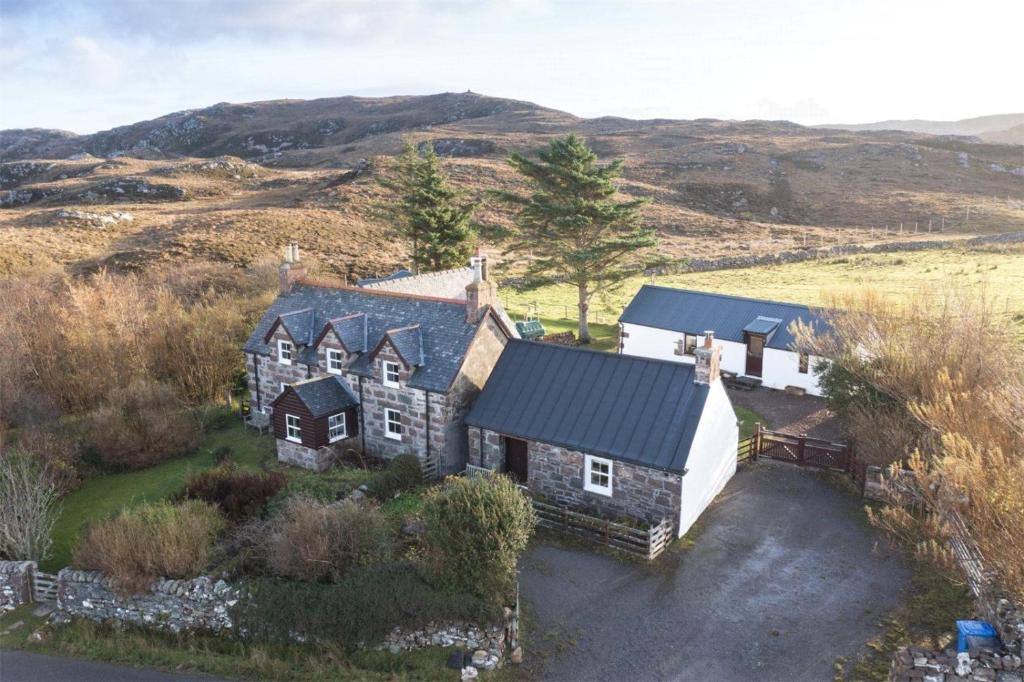 an aerial view of a house in the hills at The Smithy House & Cottages in Lochinver