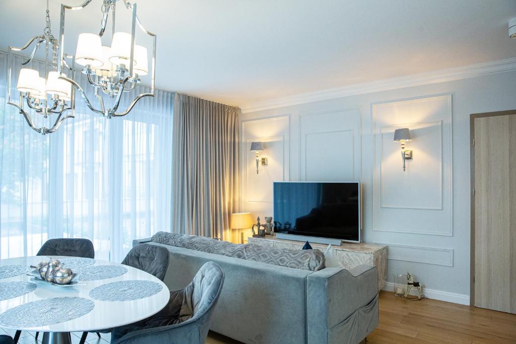 a living room with a couch and a tv at Top Premium Apartement in Świnoujście