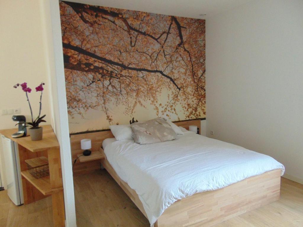 a bedroom with a bed and a painting on the wall at Relais de la Diligence in La Roche-en-Brenil