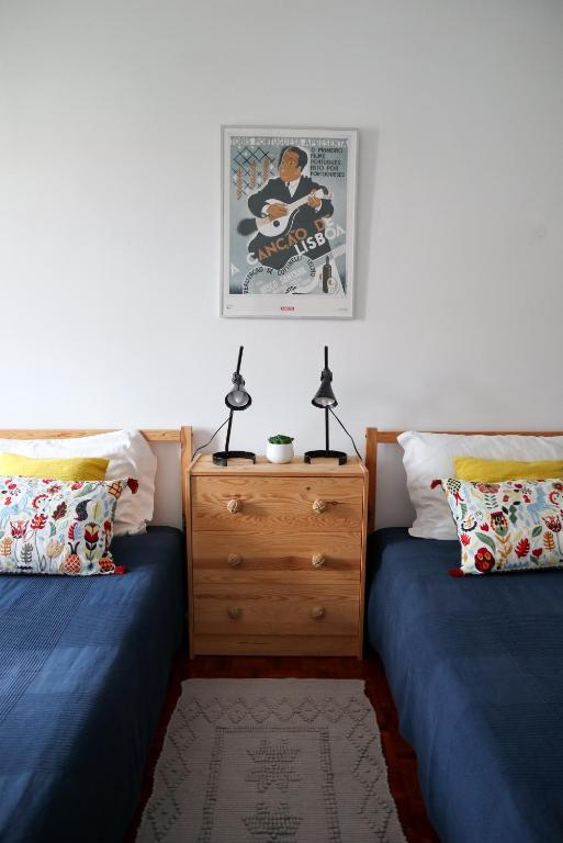 a bedroom with two twin beds and a dresser at Ana's Guesthouse in Sintra