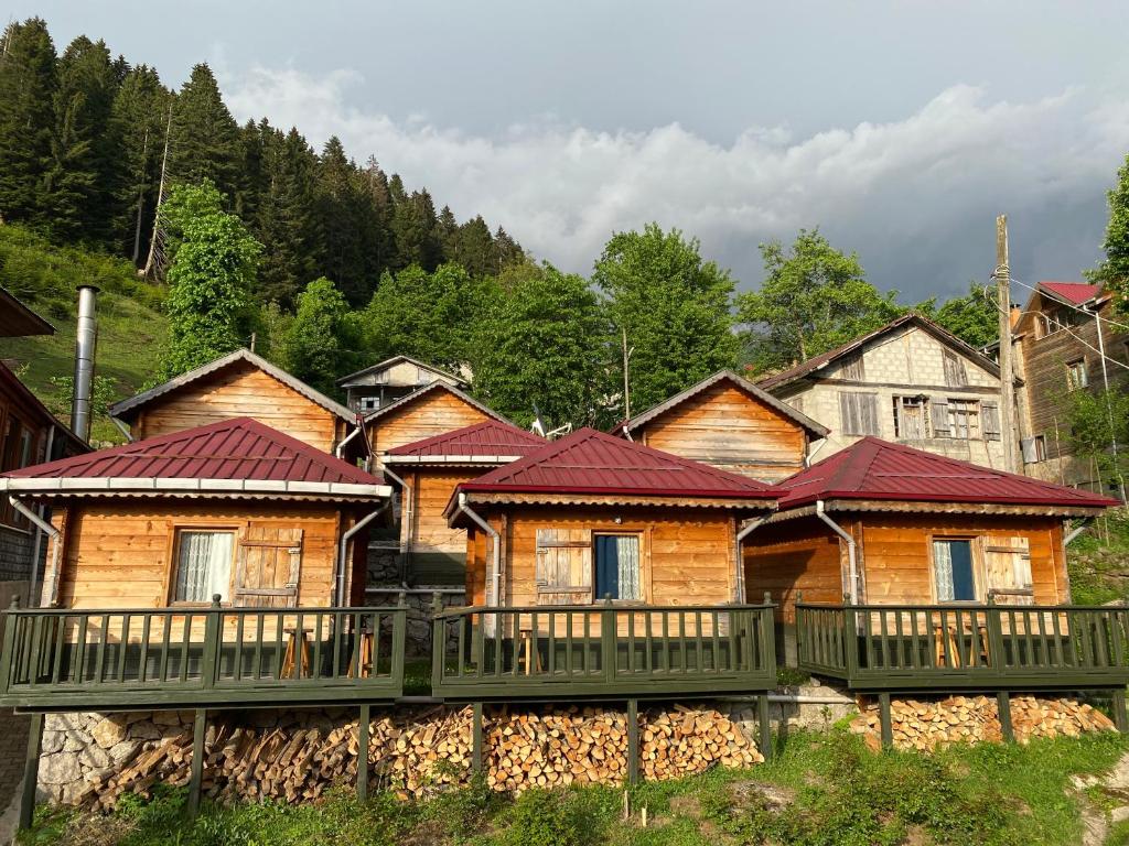 un grupo de casas de madera con techos rojos en Pilita Bungalov&Rest en Ayder Yaylasi