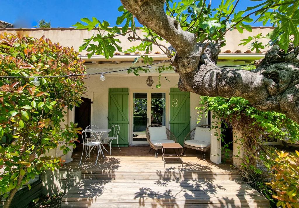 un porche de una casa con sillas y un árbol en Hôtel Sous les Figuiers - Piscine, parking, centre ville, en Saint-Rémy-de-Provence