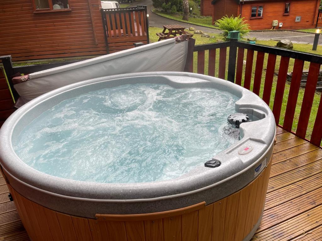 a jacuzzi tub sitting on top of a deck at L02 - The Penrhyn Spa with Hot Tub in Bethesda