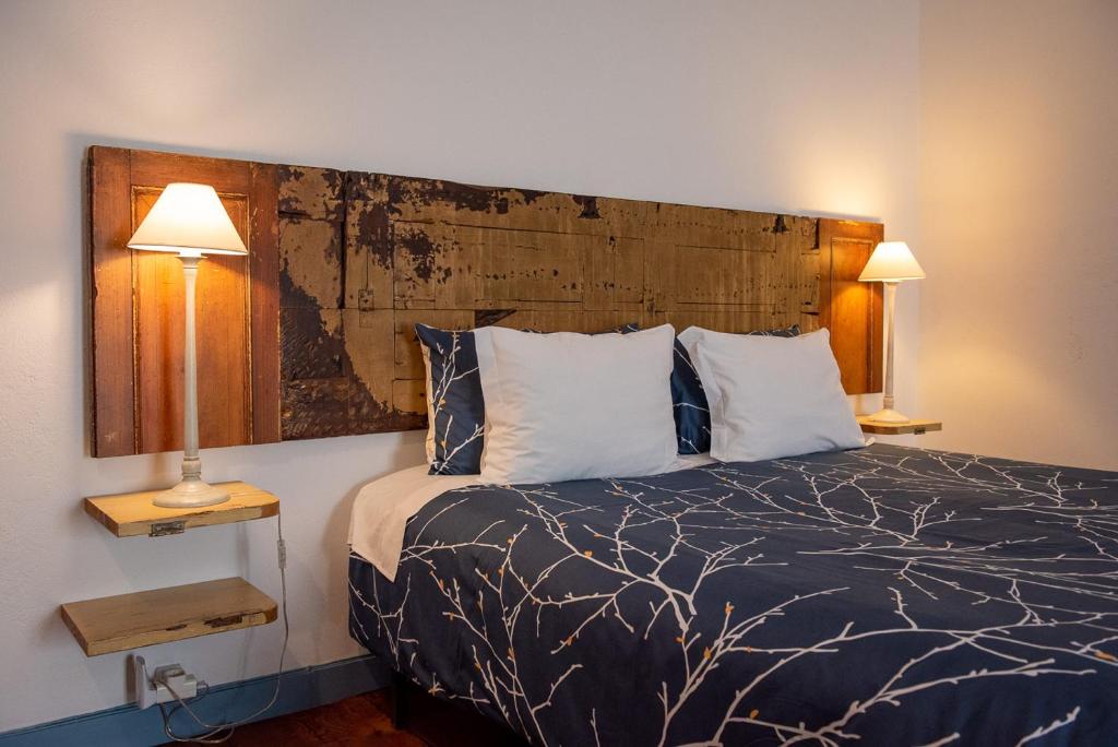 アングラ・ド・エロイーズモにあるCasadangra, bnbのベッドルーム1室(大きな木製ヘッドボード付きのベッド1台付)