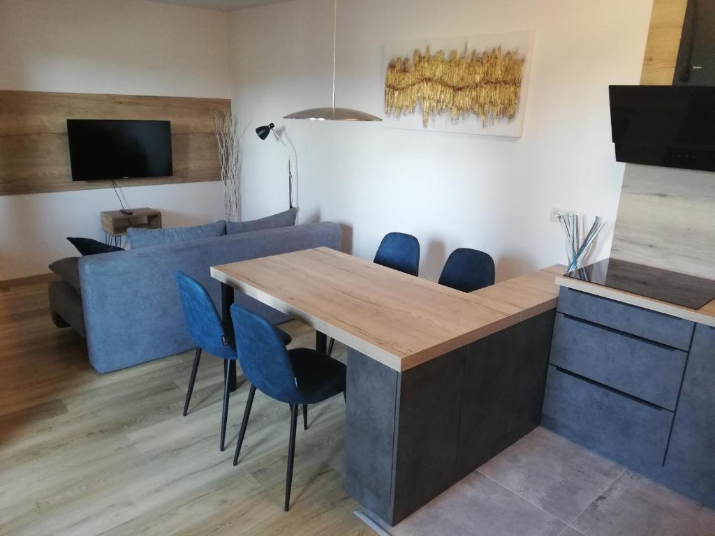 een woonkamer met een tafel en een blauwe bank bij Apartment Leggero in Moravske-Toplice