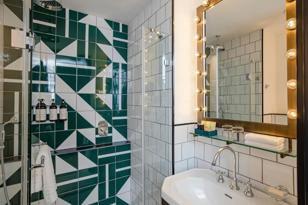 a bathroom with a green and white tiled wall at Backstage Hotel - an Atlas Boutique Hotel in Tel Aviv