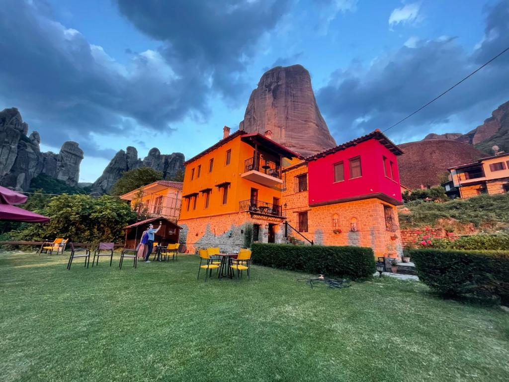 a building with a mountain in the background at Archontiko Mesohori Meteora in Kalabaka