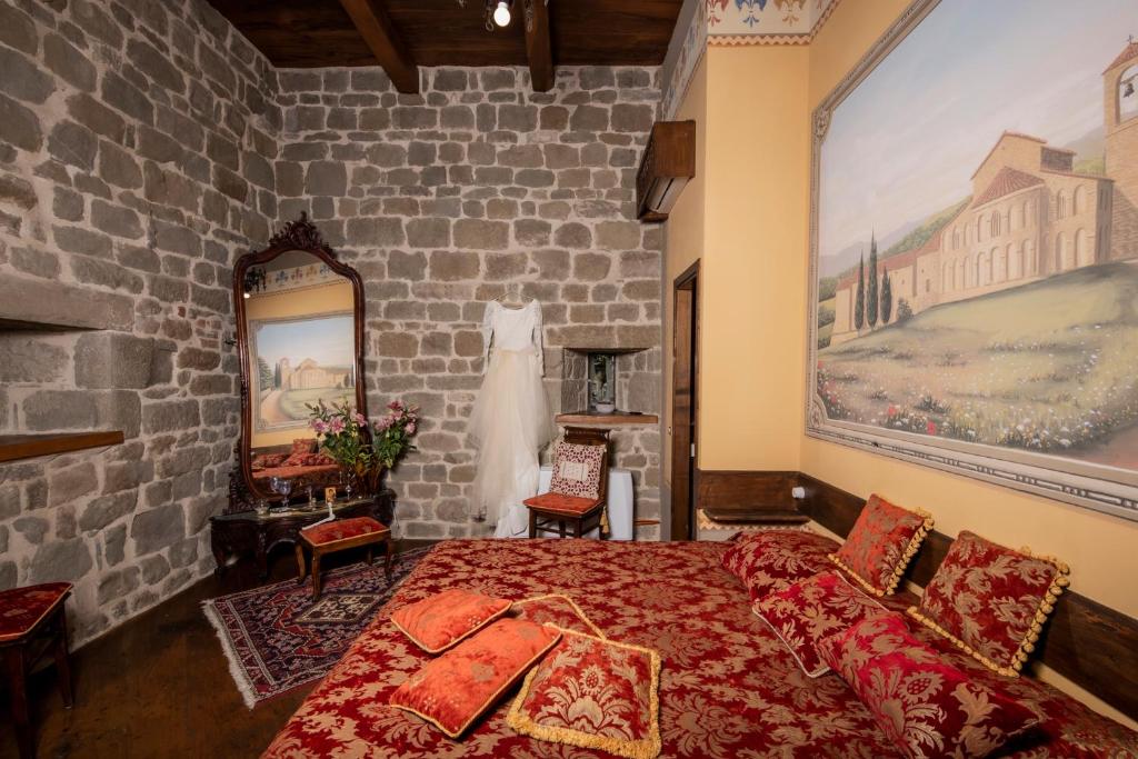 a bedroom with a bed and a dress hanging on a wall at Medieval Tower Lungarno your wedding in Tuscany in Pratovecchio