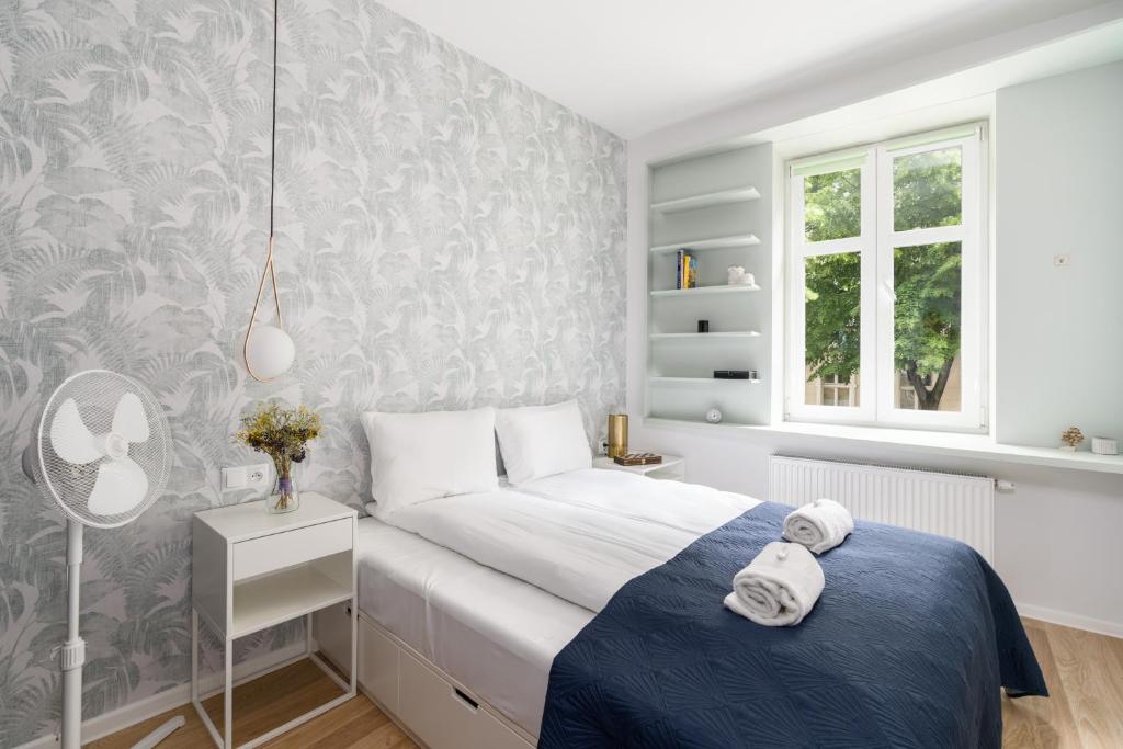 a small bedroom with a bed and a window at Poznań City Center Sikorskiego by Renters in Poznań