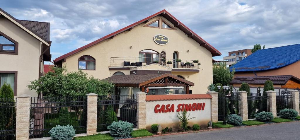 a large house with a black fence in front of it at Pensiunea Casa Simoni in Ploieşti