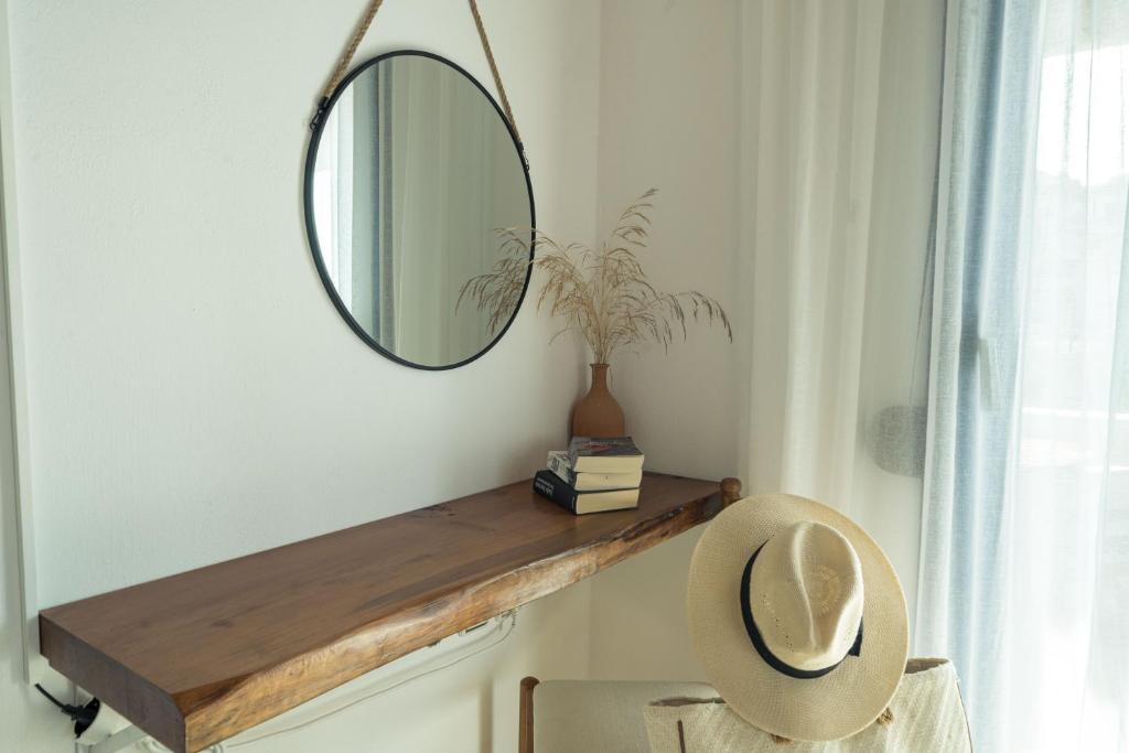 a mirror on a wall next to a chair in a room at Sunset Home Crete in Paránimfoi