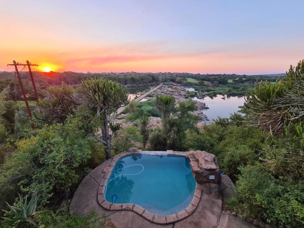 an overhead view of a swimming pool and a lake at River Hill Lodge in Komatipoort