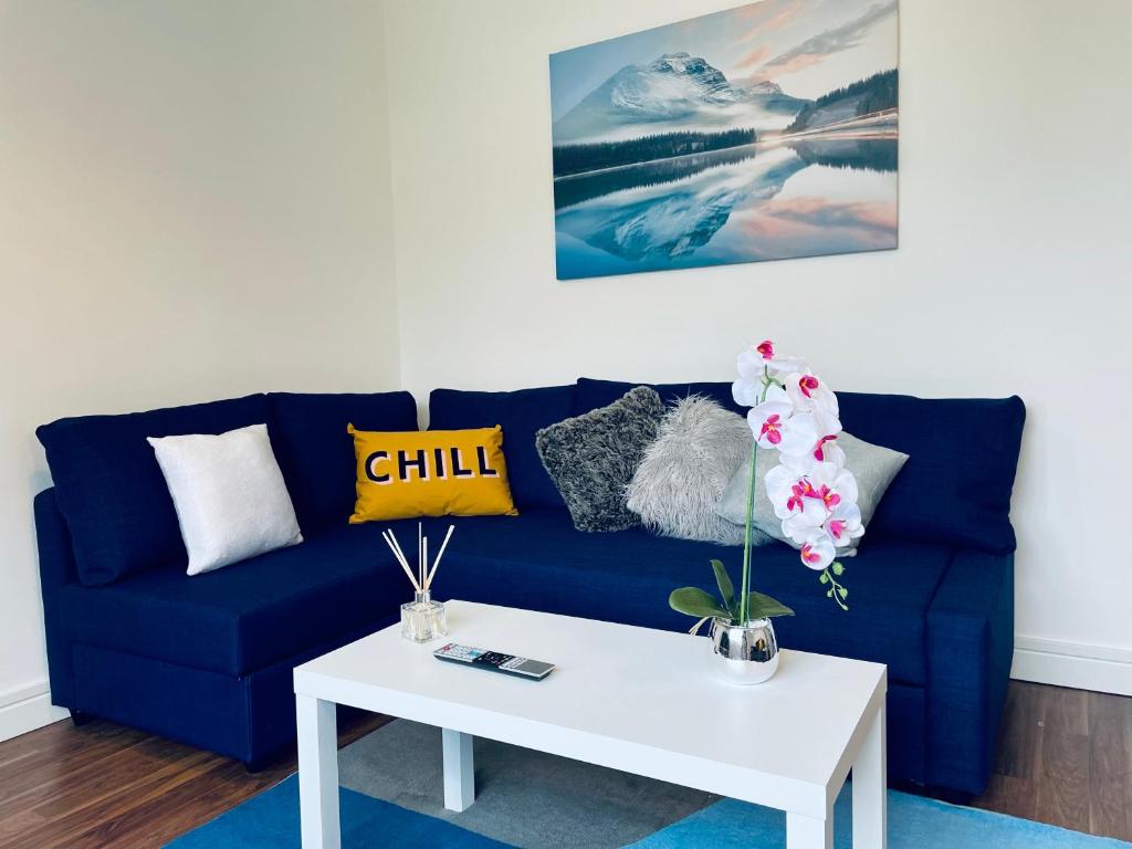 a blue couch with a white coffee table in a living room at Spacious and Bright 2 Bedroom Apartment, Sleeps 6, 1st Floor with Free Parking, Business and Leisure by Jesswood Properties in Hinckley