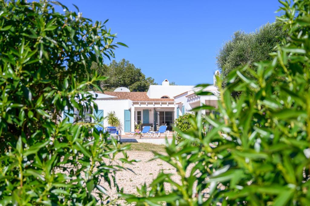 a view of a house through the trees at Quite villa with private pool in Binibeca in Binibeca
