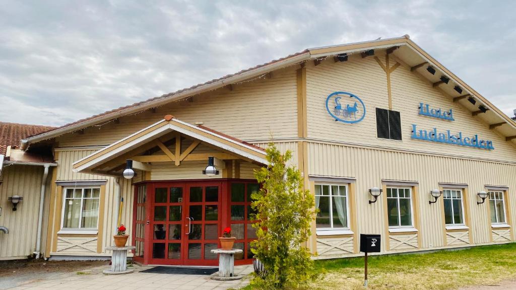 a large building with a red door in front at Hotell Indalsleden in Bispgården