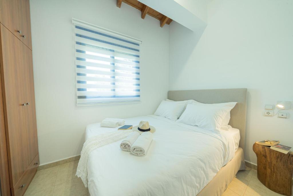 a bedroom with a bed with towels and a window at Sunset Home Crete in Paránimfoi