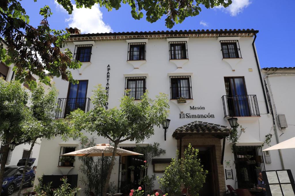 un edificio blanco con un paraguas delante en Plaza de los asomaderos 54 Grazalema, en Grazalema