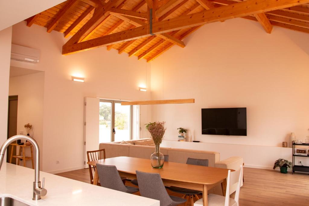 comedor y sala de estar con mesa de madera en Palmira's - relaxing countryside house in Batalha, en Batalha