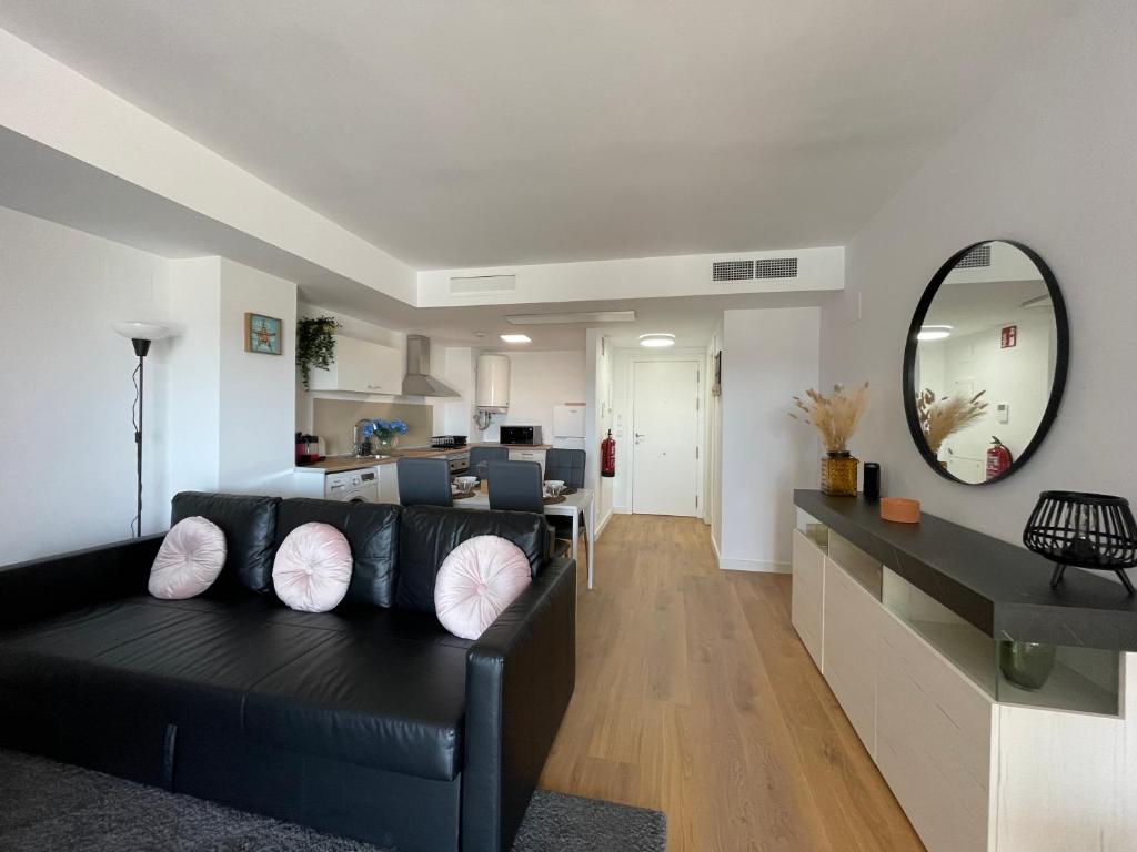 uma sala de estar com um sofá preto e um espelho em Canet De Berenguer, Playa Apto con 2 habitaciones em Valência