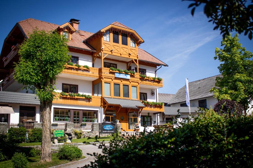 een groot geel gebouw met planten erop bij Pension Kärnten in Seeboden
