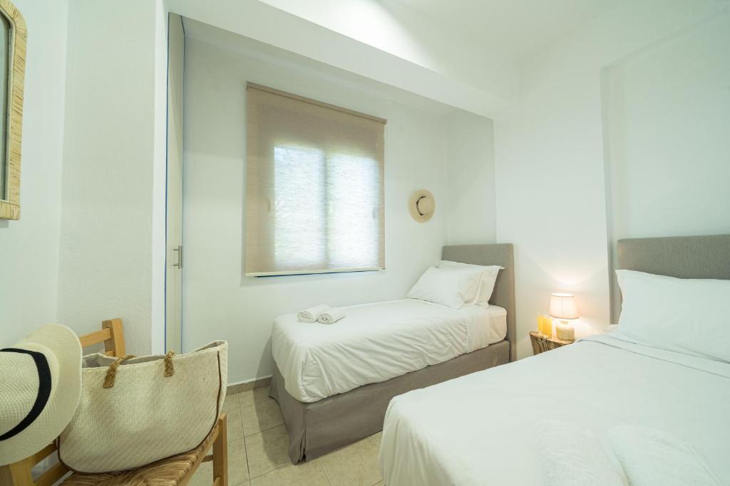 a small bedroom with two beds and a window at Sunset Home Crete in Paránimfoi
