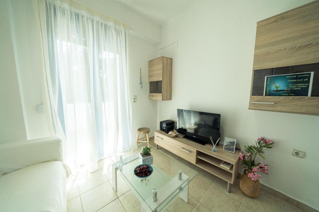 a living room with a couch and a television at Sunset Home Crete in Paránimfoi
