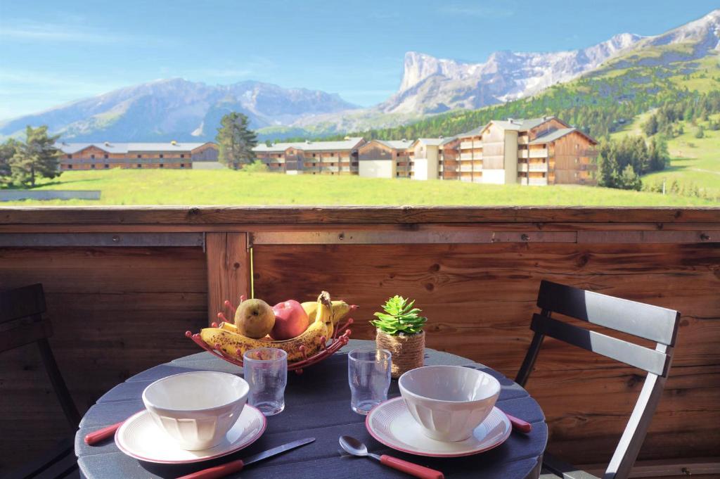 einen Tisch mit einer Obstschale auf dem Balkon in der Unterkunft Vue panoramique tout confort 150m pistes commerces et loisirs in Le Dévoluy