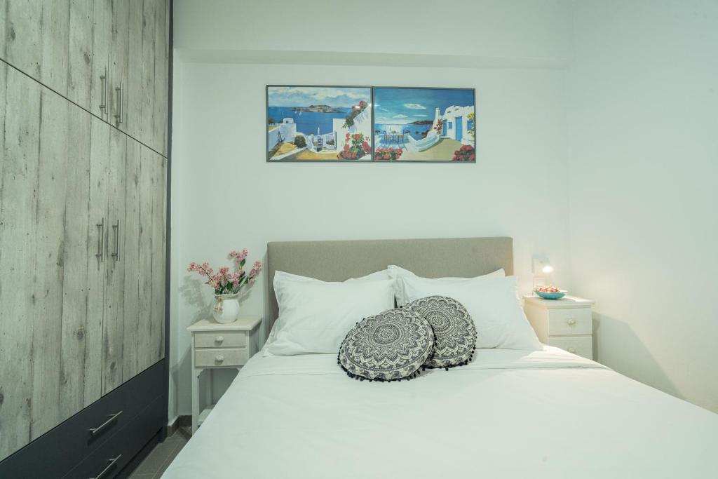 a bedroom with a white bed with a pillow on it at Sunset Home Crete in Paránimfoi