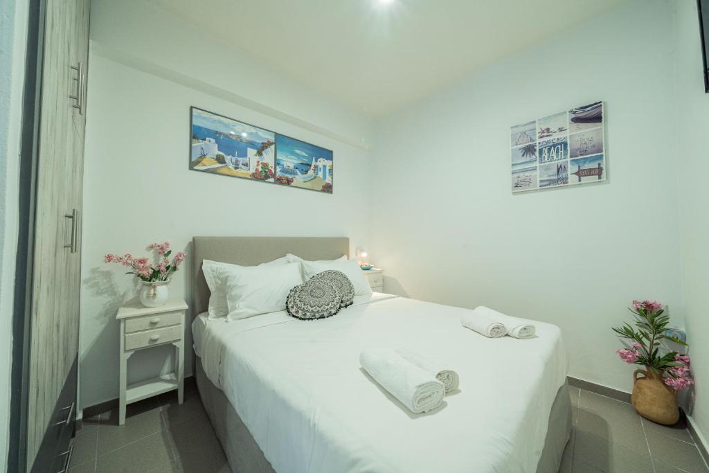 a bedroom with a white bed and a night stand at Sunset Home Crete in Paránimfoi